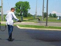 Image showing a great example of a man sealcoating with a sprayer system