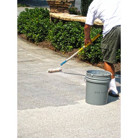 image of a man applying clear driveway concrete sealer