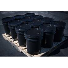 Pallet showing twelve buckets of 5 gallon BIGA asphalt sealer